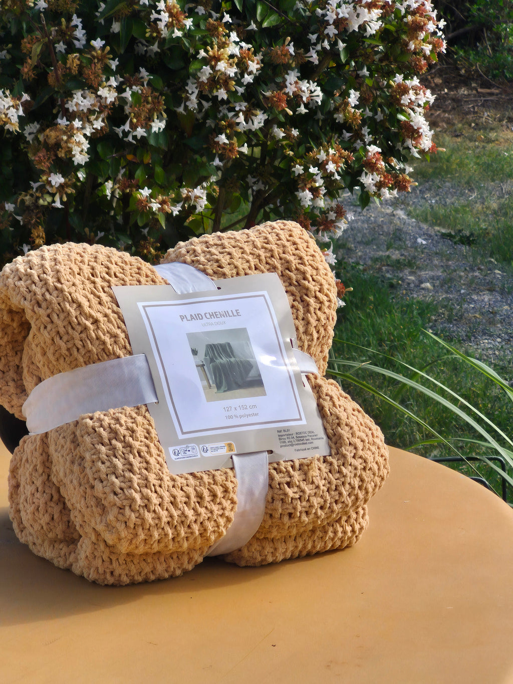 Plaid chenille beige photographié en extérieur